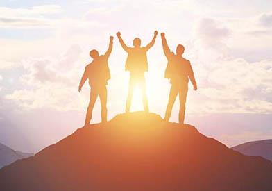 3 people celebrating on top of a summit